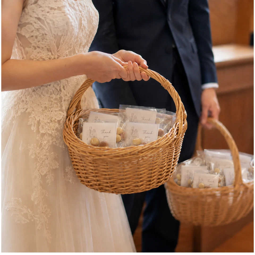 新郎新婦がプチギフトのかごを持つイメージ