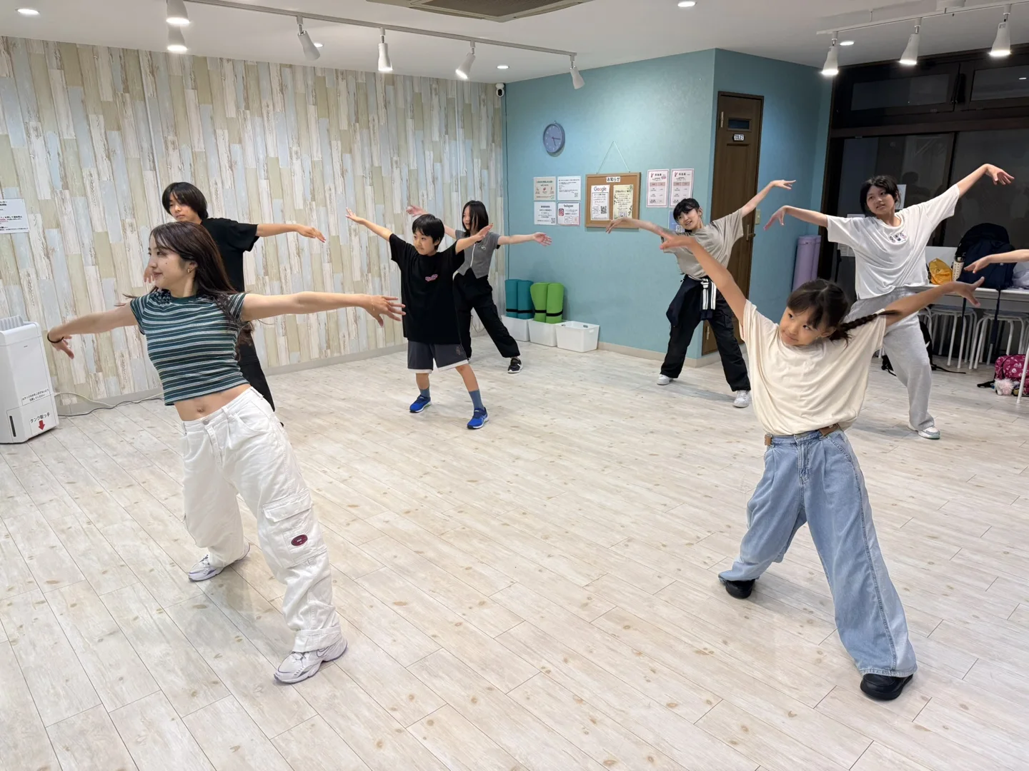 明るいスタジオで講師と一緒に踊る子どもたち